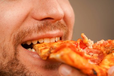 A man enjoys a slice of cheese pizza, enjoying a slice of the classic snack. Perfect concept for food and restaurant visuals clipart