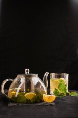 Zencefilli, limonlu ve naneli sıcak bitki çayı. Şeffaf çaydanlıkta zencefilli içecek. Sağlıklı limon çayı