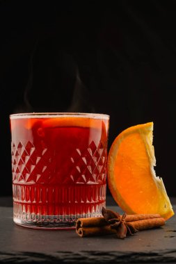 Sıcak kırmızı şarap, yakın plan. Duman siyah arkaplanda görünür.