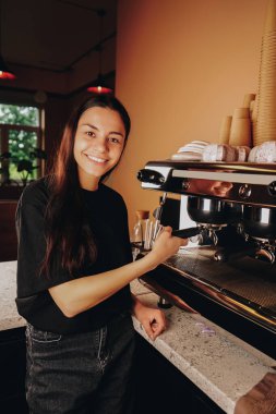 The barista smiles warmly as she operates the coffee machine, blending precision and charm while preparing a fresh, aromatic espresso clipart