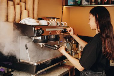 Kahveciden hafif bir tezahürat. Latte sanatını mükemmelleştiriyor. Gururu ve kahve yapma aşkı küçük bir sevinç anında parlıyor.