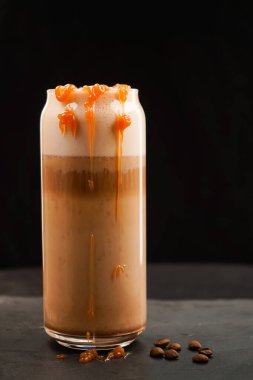 Büyük bardakta buzlu karamel latte kahve şerbetli ve kremalı.
