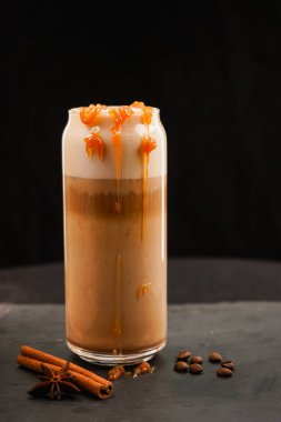 Koyu arkaplanda balkabaklı latte. Kremalı balkabağı aromalı latte. Sonbahar içkisi. Minimalizm. Boşluğu kopyala