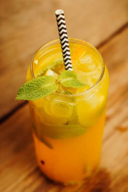 Canlı nane yapraklı limonata, koyu renk bir tuvale takılır. Renklerin kontrastı ve buzlu içecek onu nihai susuzluk giderici yapar.