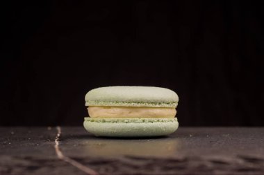 Siyah arkaplandaki naneli badem kurabiyelerinin yakın plan görüntüsü çiğnenmiş dokularını ve tatlı dolgusunu vurguluyor. Konsept, şekerleme, tatlı ve gıda tasarım kavramları için uygundur.