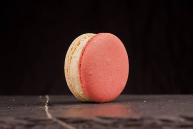 Şeftali rengi badem kurabiyelerinin yakın plan görüntüsü çiğnenmiş dokularını ve tatlı dolgusunu vurguluyor. Konsept, şekerleme, tatlı ve gıda tasarım kavramları için uygundur.