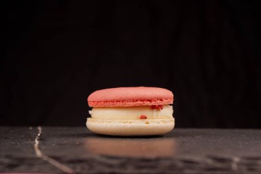 Şeftali rengi badem kurabiyelerinin yakın plan görüntüsü çiğnenmiş dokularını ve tatlı dolgusunu vurguluyor. Konsept, şekerleme, tatlı ve gıda tasarım kavramları için uygundur.