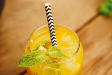 Limonata, narenciye ve nane filizlerinin ferahlatıcı bir karışımı arka planda göze çarpıyor. Keskin, tatlı ve bitkisel notaların mükemmel bir karışımı.