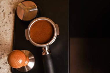 Yakından izole edilmiş taze espresso kahvesiyle dolu siyah paslanmaz çelik filtre tutacağı.