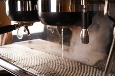 Profesyonel bir kahve makinesiyle bir kafede kahve yapmak. Arka planda bir kahve dükkanında.