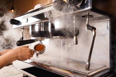 Barista Kafe 'nin yakın plan kahvesi. Kahve makinesini kurcalayarak el yapımı kahve yapıyor.