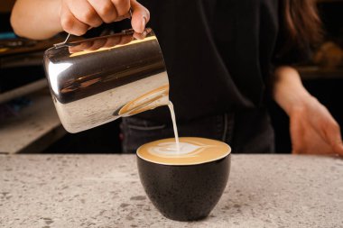 Cappuccinatore 'dan koyu süt köpüğüyle kapuçino demleme işleminin yakın çekimi