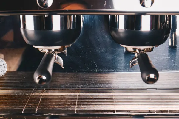 Kahve makinesinin yakın çekimi, kahve yapmak için mükemmel tasarlanmış düğmeleri ve kollarıyla dayanıklı yapısını gözler önüne seriyor.