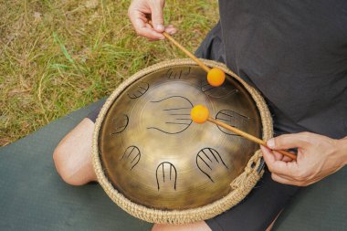 Parlak turuncu çubuklar eşliğinde orman zeminine bir pervane yerleştirilir. Uzakta bulanık ağaçlar barışçıl atmosferi güçlendirir. Bir adam glukometrede bir melodi çalar