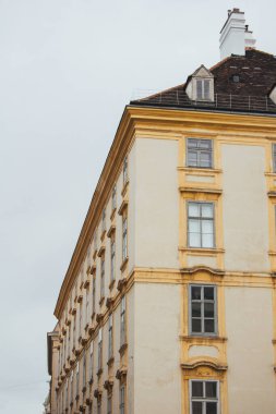 Viyana, Avusturya - 12 Mayıs 2019: Antik Avrupa binalarının mimarisi. Ahşap pencereli eski sarı bina.