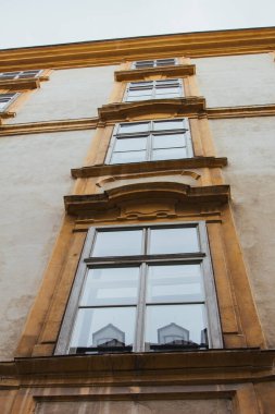 Viyana, Avusturya - 12 Mayıs 2019: Kirli sarı binanın eski ahşap pencereleri. Konut binalarının antik mimarisi