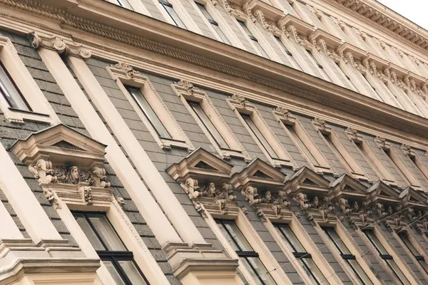 Viyana, Avusturya - 12 Mayıs 2019: Konut binalarının antik mimarisi. Seçkin bir ev, pencerelerinin yakın plan fotoğrafı. Dairelerin Avrupa mimarisi. Aşağıdan yukarıya doğru ham pencereler