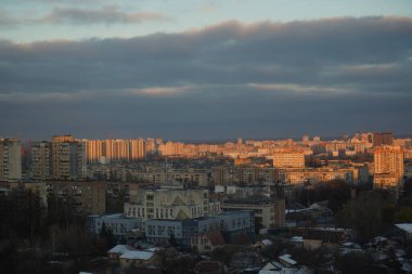 Pencereden bak, arkasından bir kış köyü manzarası. Karla kaplı ağaçlar ve derin kar