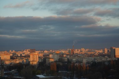 Uzakta pek çok ev var, hafif karla kaplı, aydınlık güneşin ağırlığı altında.