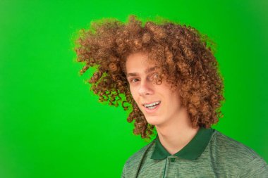 Chroma Key 'in parlak yeşil rengi buklelerin ve genç adam gömleğinin neşeli hareketlerini vurguluyor.