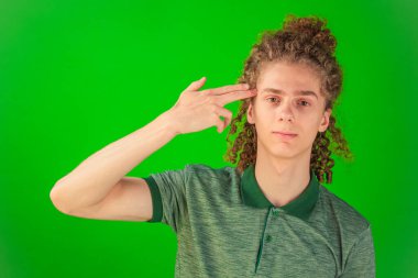 Saf inançsızlığını ifade eden kıvırcık saçlı adam çarpıcı bir şekilde tepki veriyor, canlı duyguları parlak Chroma Key yeşiliyle çelişiyor.