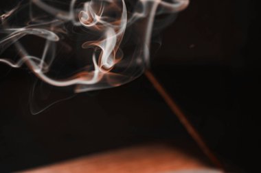 Meditasyon ve rahatlama için yanan tütsü dumanı çubuğu. Aromaterapi yoga için sigara içer. Aroma dumanı siyah arka planda, beyaz arka planda. Tütsülenmiş duman dumanı ve perdeler