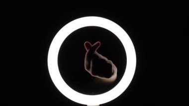 Bir sürü jest. Kadın eli yakın plan parmak figürleri yapar. Parmak oyunu, kalp şeklinde avuçlar. Eller aşkın sembolünü gösterir.