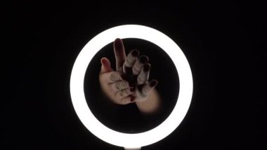 Kadın elleri, kremi siyah arka planda yakın plan avuçlarına sürterler. Güzellik tedavileri, spa, cilt bakımı.