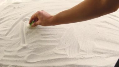 hand draws the inscription Bulgaria on the sand. Sunny coast of the sea and ocean. Symbol of rest and vacations at the resort.