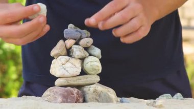 İnsanoğlu deniz taşlarından bir piramit inşa eder. Yumuşak çakıl yığını. Zen taşları yakın plan. Huzur ve dinlenme konsepti..
