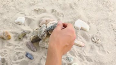 İnsanoğlu deniz taşlarından bir piramit inşa eder. Yumuşak çakıl yığını. Zen taşları yakın plan. Huzur ve dinlenme konsepti..