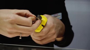 Bir uzman mücevher salonundaki altın ürünlerin kalitesini kontrol eder. Değerli metalleri parçalamak için halka ve zincir kesmek. Bir rehinci dükkanında pahalı malların uzmanlığı ve incelenmesi.