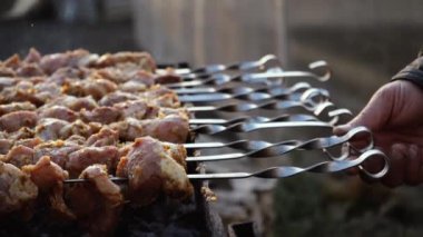 Sokakta mangal mangalında mangal yapan bir adam. Barbekü dışarıda. Doğada piknik. Izgara etle şiş kebap yapıyor..
