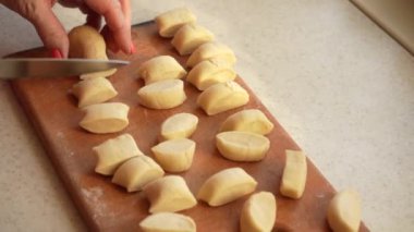 Efendinin elleri hamuru parçalara ayırdı. Buğday unundan yapılıyor. Evde yemek pişirmek..