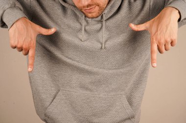 İki eliyle işaret ederek dikkatleri daha düşük bir noktaya odaklıyor. Kusursuz jesti ilgi çekici ve kasıtlı. Resim berraklığı ve amacı iletir.
