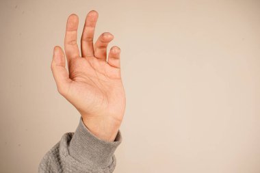 Avuç içi açık bir şekilde, dur hareketi sahnenin ortasına gelir. Minimalist arka plan pozun dobralığını vurgular. Evrensel bir farkındalık ve kendini kontrol işareti.