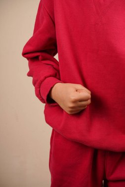 Kaldırılmış bir yumruk hafif bir duvara dayanır, gücü ve iç gücü simgeler. Tarafsız arka plan, belirleyici jestlere dikkat çekiyor. Evrensel bir güç sembolü.