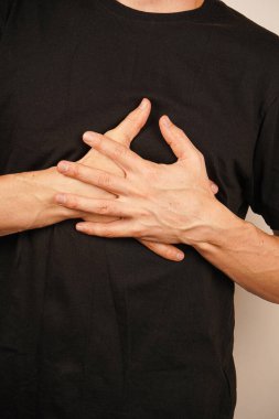 Adamın elleri sembolik olarak birbirinin üstüne binmiş. Işık duvarı temiz ve ince bir zemin görevi görüyor. Elleri duygusal dengeyi ve bağlantıyı vurguluyor. Evrensel anlamı olan bir jest.