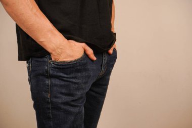 Ellerini kotunun cebine sokmuş, adam rahatça ayakta duruyor. Günlük kıyafet ve rahat poz kendine güvenen ve rahat bir atmosfer yaratır. Bir anlık huzur.