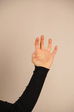 Parmakları pençe şeklinde kıvrılmış bir kedi pençesi izlenimi yaratıyor. Bu jest, kedilerin zarafetini sembolize eden vahşi içgüdülerin birleşimi. Yaratıcı ya da hayvan temalı projeler için mükemmel