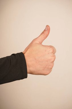 Tek bir el, baş parmağını yukarı kaldırarak onay ve pozitifliği sembolize ediyor. İkonik 