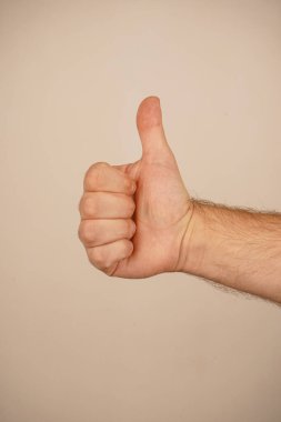 A single hand with a thumb raised upward, symbolizing approval and positivity. The iconic 