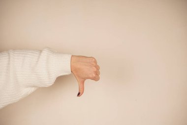 Thumbs down in a general sign of disapproval. This simple yet powerful gesture signifies rejection or disagreement. Neutral background provides focus on the gesture of dislike clipart