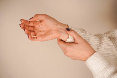 One hand grasps the wrist of the other in a gesture of union. This pose symbolizes support, unity, or strength. Pulse measurement on the wrist. The neutral background emphasizes its emotional depth clipart