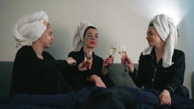Kafalarına beyaz havlu sarılmış kadınlar bekarlığa veda partisini bir bardak alkolle kutluyorlar. Yüzünde yamalar var.