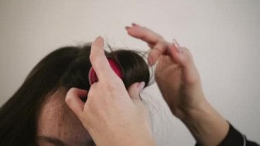 Üç kadın, odanın ortasında küçük plastik bir aynanın önünde saç şekilleri oluşturarak ve kalpten duygular paylaşarak birlikte vakit geçirir.