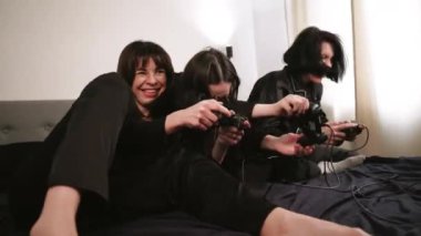 Siyah pijamalı üç kadın ellerinde joysticklerle bir gece dışarı çıkmanın keyfini çıkarıyorlar. Bir dizüstü bilgisayarın etrafında arka planda bir ışık duvarına karşı toplanmışlar.