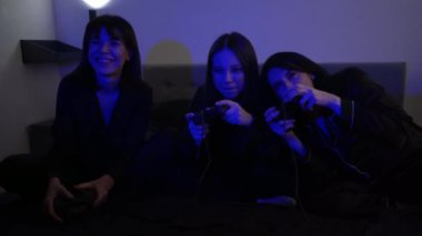 Bir grup pijamalı arkadaş, şampanya içerken ve sıradan bir ortamda oyun oynarken dizüstü bilgisayarlarına bakarken rahatlar. Mavi ışığın arka planında