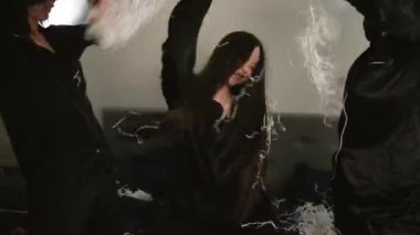 Pijama partisi sırasında, kendine iyi bakılan ve iyi titreşimli eğlenceli bir an. Siyah saten pijamalı üç genç kadın dans ediyor ve yılan kurdelesiyle şarkı söylüyor.