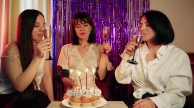 Masanın üzerinde mumların sıkıştığı çörekler var. Doğum günü kutlaması sanki bir doğum günüymüş gibi neşeli bir şekilde gerçekleşiyor.